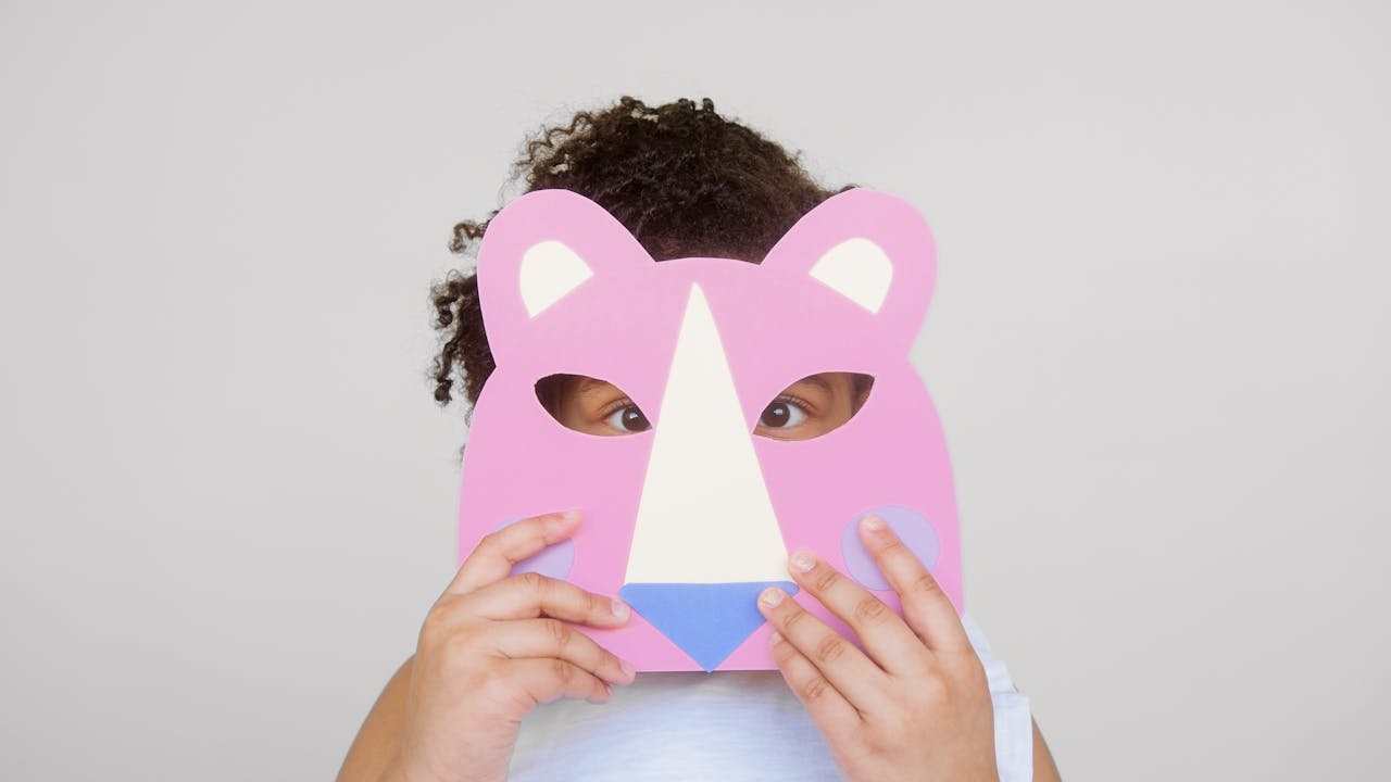 Girl Covering Her Face With a Cutout Animal Mask